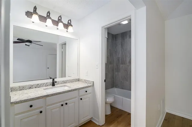 a bathroom with a granite countertop sink toilet and shower