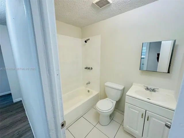 a white toilet sitting next to a bathroom sink and a shower