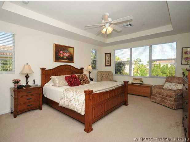 134 Southwest Walking Path Stuart, FL 34997 - Photo 12 of 25 Master Bedroom. Master Bedroom Suite, Sitting Area, Views of the Preserve, Tray Ceiling, Upgraded carpeting & ceiling fan