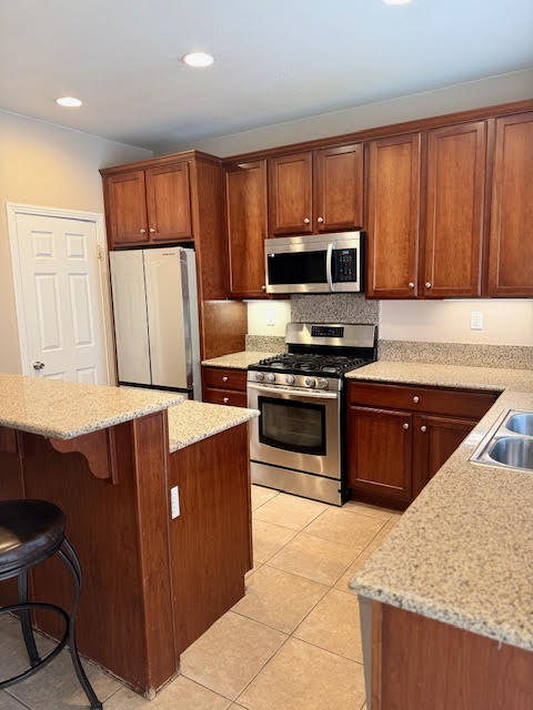 84476 Ruebens Way Coachella, CA 92236 - Photo 42 of 47 a kitchen with wooden cabinets a refrigerator and a stove top oven