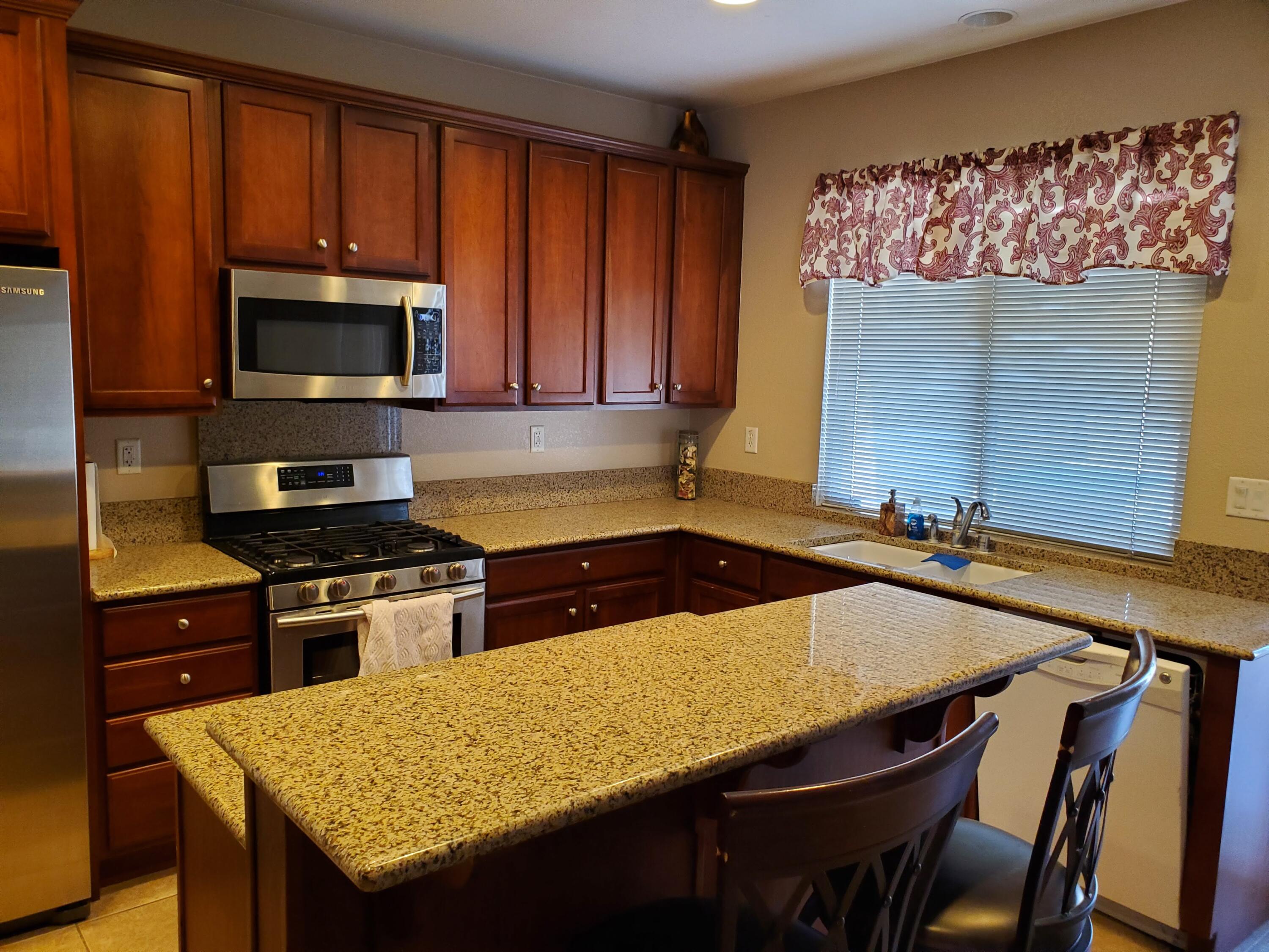 84476 Ruebens Way Coachella, CA 92236 - Photo 5 of 47 a kitchen with a stove a sink and a microwave