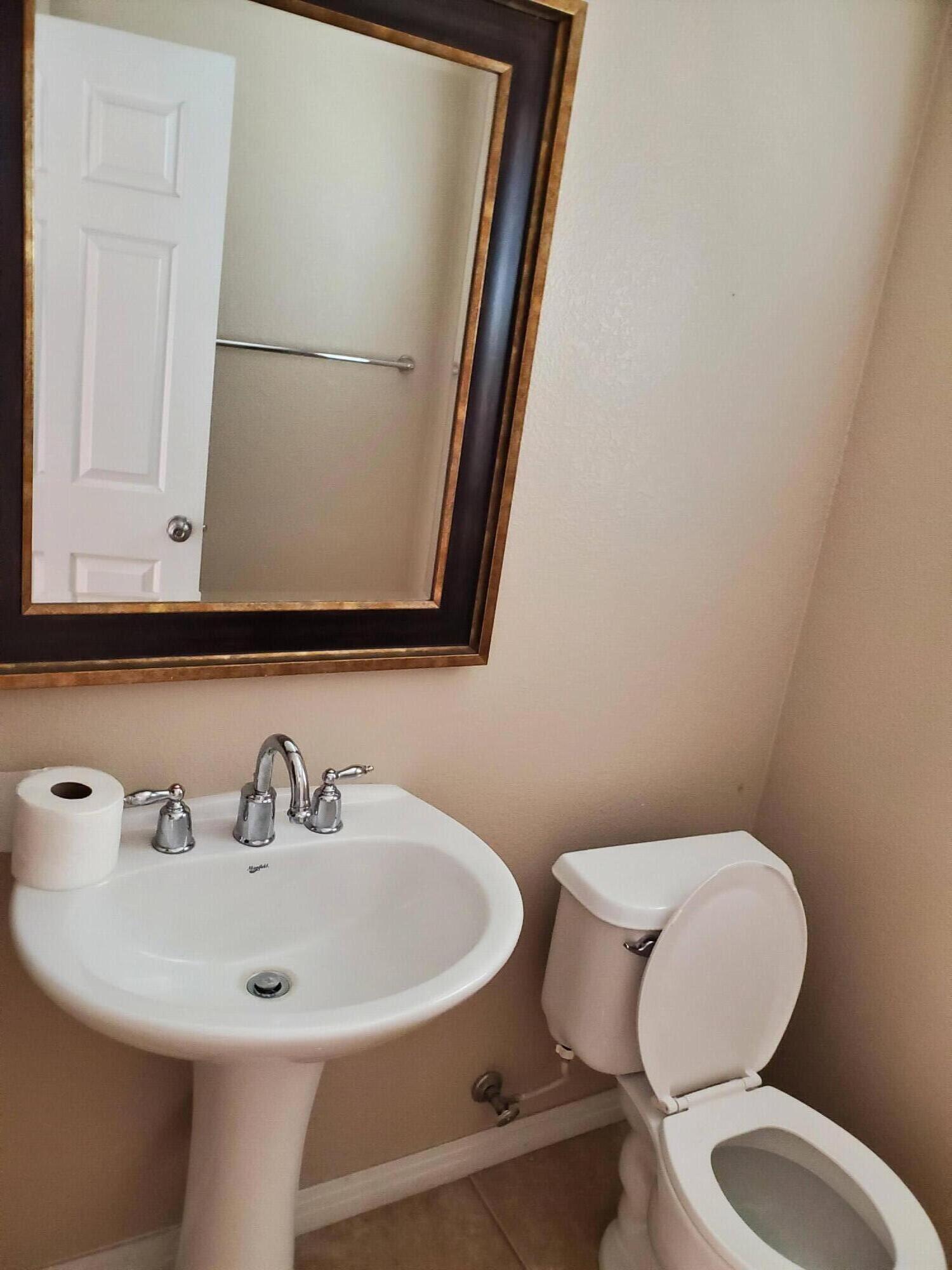 84476 Ruebens Way Coachella, CA 92236 - Photo 8 of 47 a bathroom with a toilet a sink and mirror