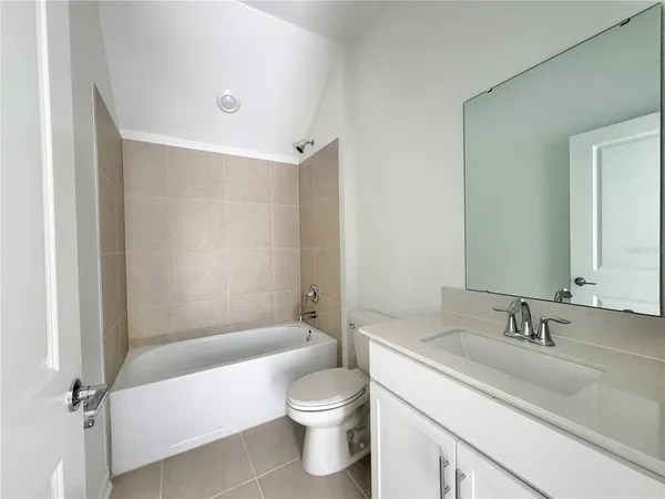 a bathroom with a granite countertop sink a toilet and shower