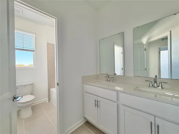 a white toilet and tub sitting next to a bathroom sink