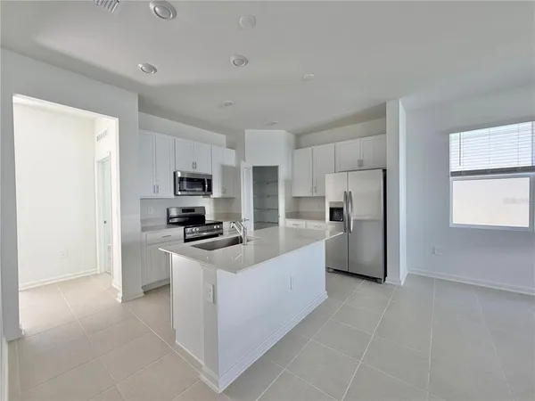 a kitchen with stainless steel appliances granite countertop a refrigerator and a stove top oven