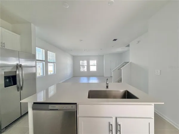 a kitchen with stainless steel appliances a sink a refrigerator and window