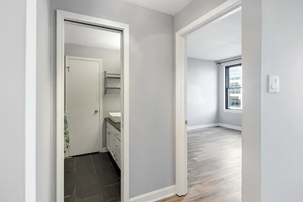 a view of an empty room with closet and a window