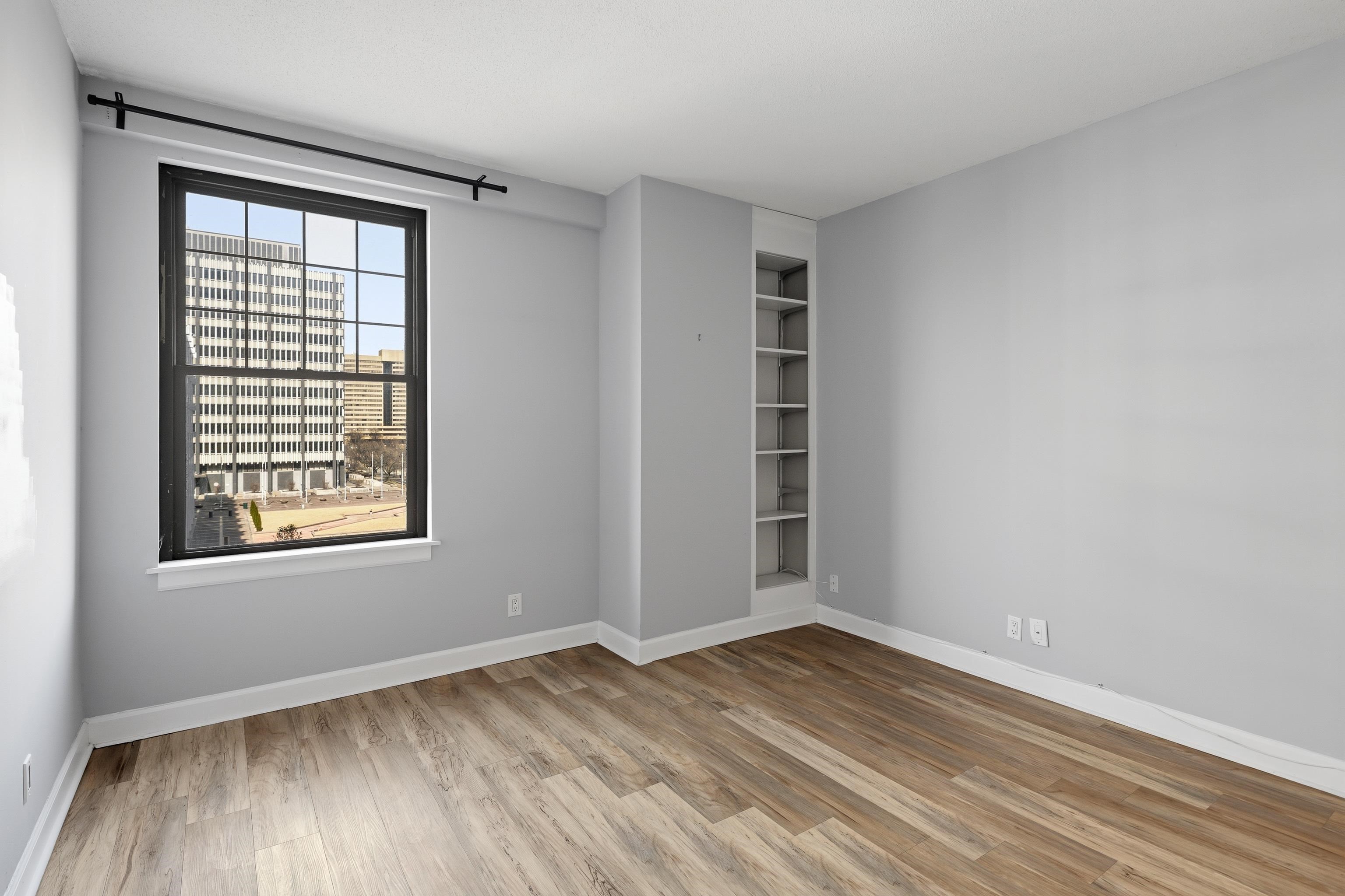 109 North Main Street, Unit 412 Memphis, TN 38103 - Photo 13 of 35 an empty room with wooden floor and windows