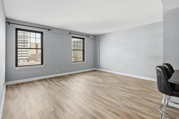 a kitchen with stainless steel appliances kitchen island granite countertop a refrigerator and chairs