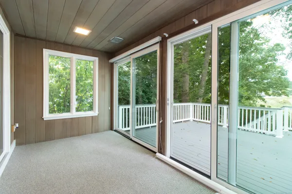 a view of backyard with large window and wooden floor