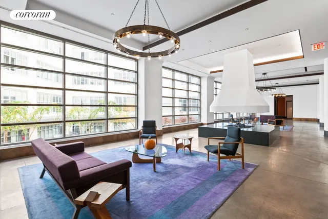 a living room with couches and a large window with pool table