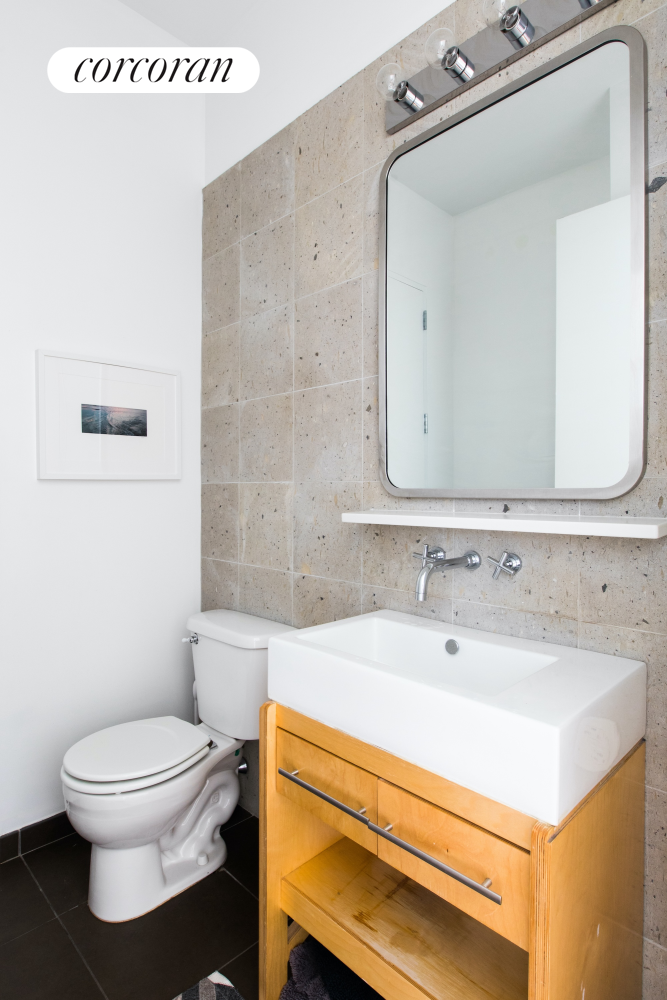 27-28 Thomson Avenue, Unit 228 Queens, NY 11101 - Photo 6 of 17 a bathroom with a sink a toilet and a mirror