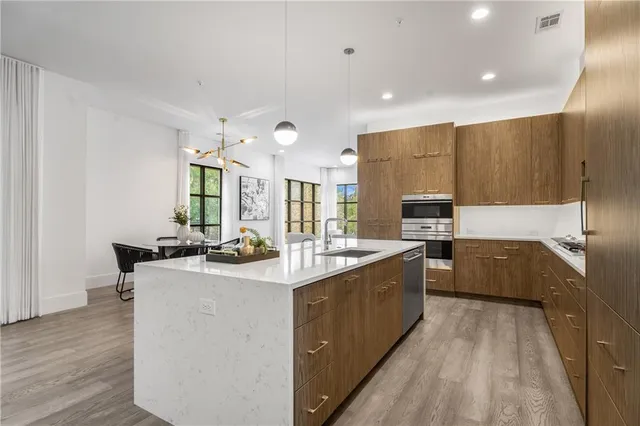 a kitchen with stainless steel appliances a sink stove and cabinets