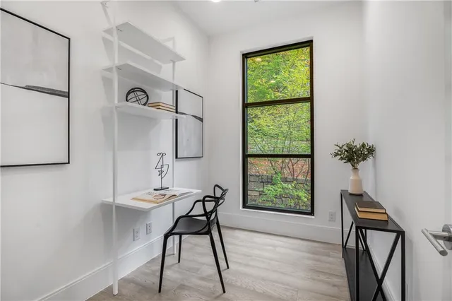 a view of a workspace with furniture and a window