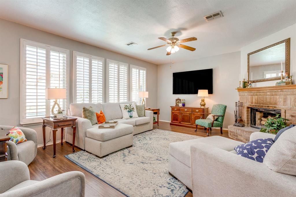 4816 Sleepy Ridge Circle Fort Worth, TX 76133 - Photo 10 of 36 Living room with a ceiling fan, wood finished floors, plenty of natural light, and a fireplace