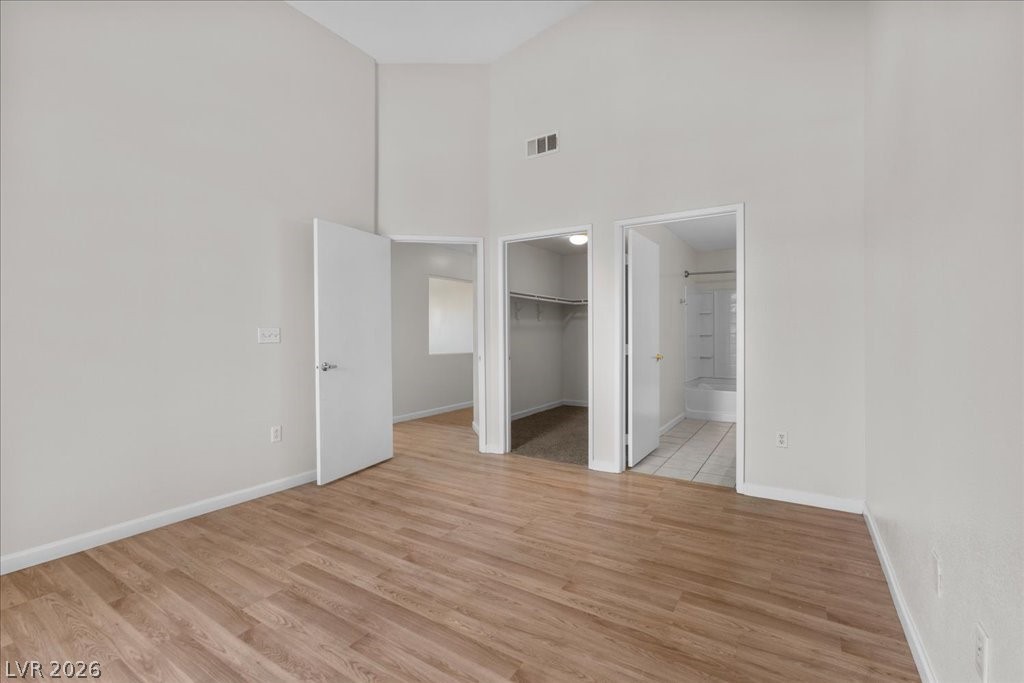 1881 West Alexander Road, Unit 1037 North Las Vegas, NV 89032 - Photo 14 of 31 A well-lit bedroom with soaring vaulted ceilings and rich wood flooring offers a versatile living space.