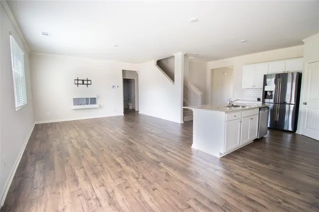 a view of a kitchen with wooden floor and electronic appliances