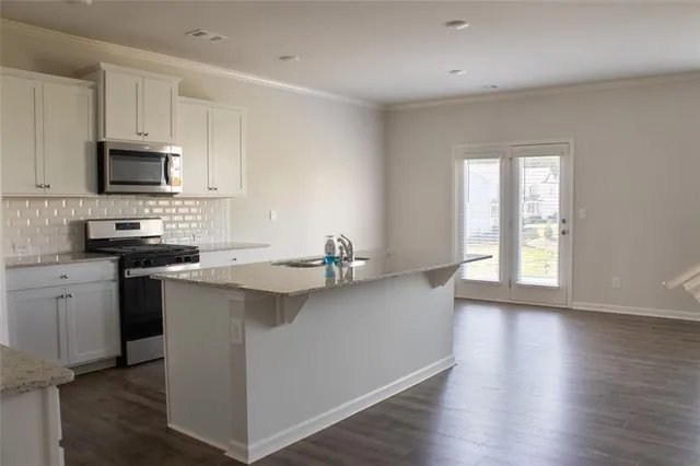 a kitchen with stainless steel appliances a sink stove and microwave