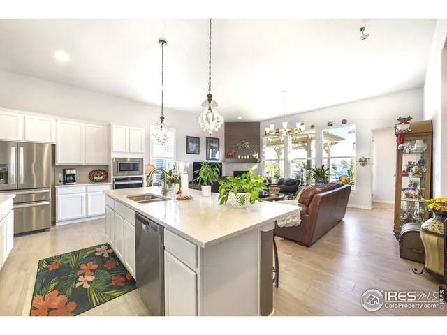 a kitchen with stainless steel appliances kitchen island granite countertop a sink cabinets and wooden floor