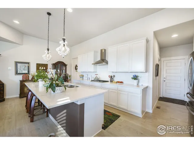 a kitchen with kitchen island stainless steel appliances a dining table and chairs