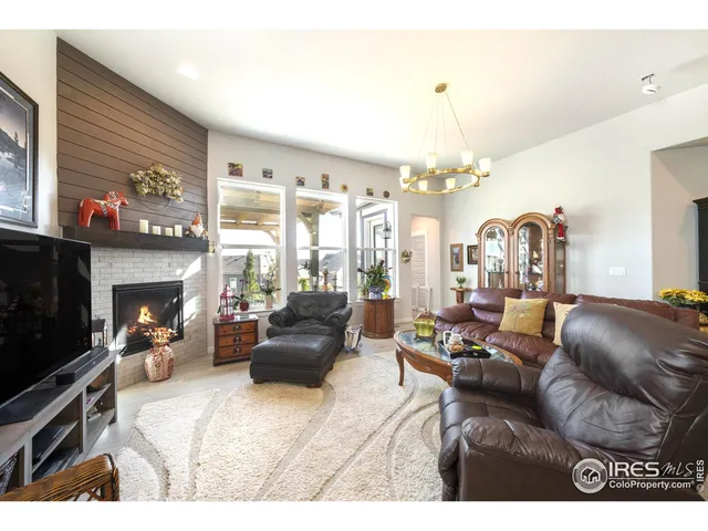 a living room with furniture a fireplace and a chandelier