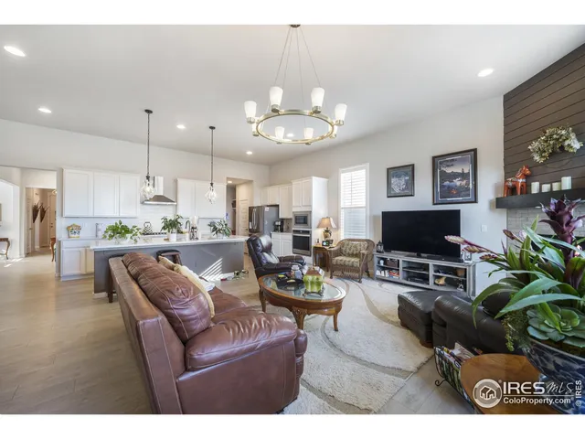 a living room with furniture kitchen view and a chandelier