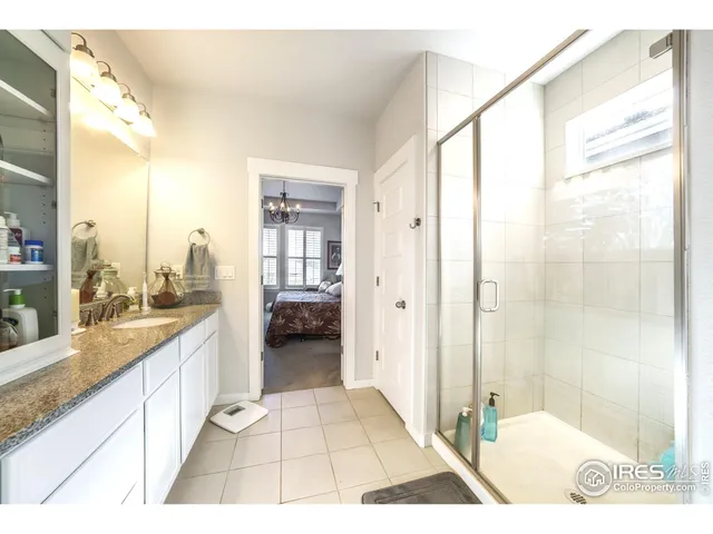 a bathroom with a granite countertop sink a mirror and a shower