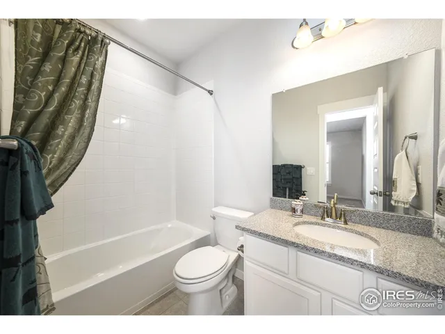 a bathroom with a granite countertop sink toilet a mirror and bathtub