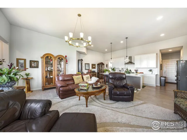 a living room with furniture kitchen view and a chandelier