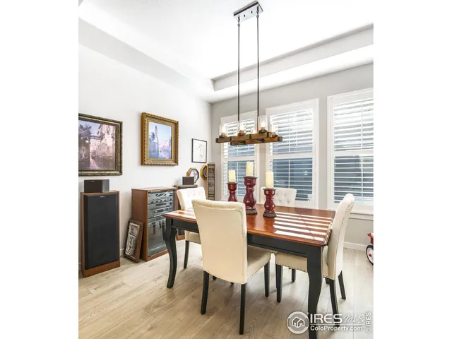 a dining room with furniture a chandelier and wooden floor