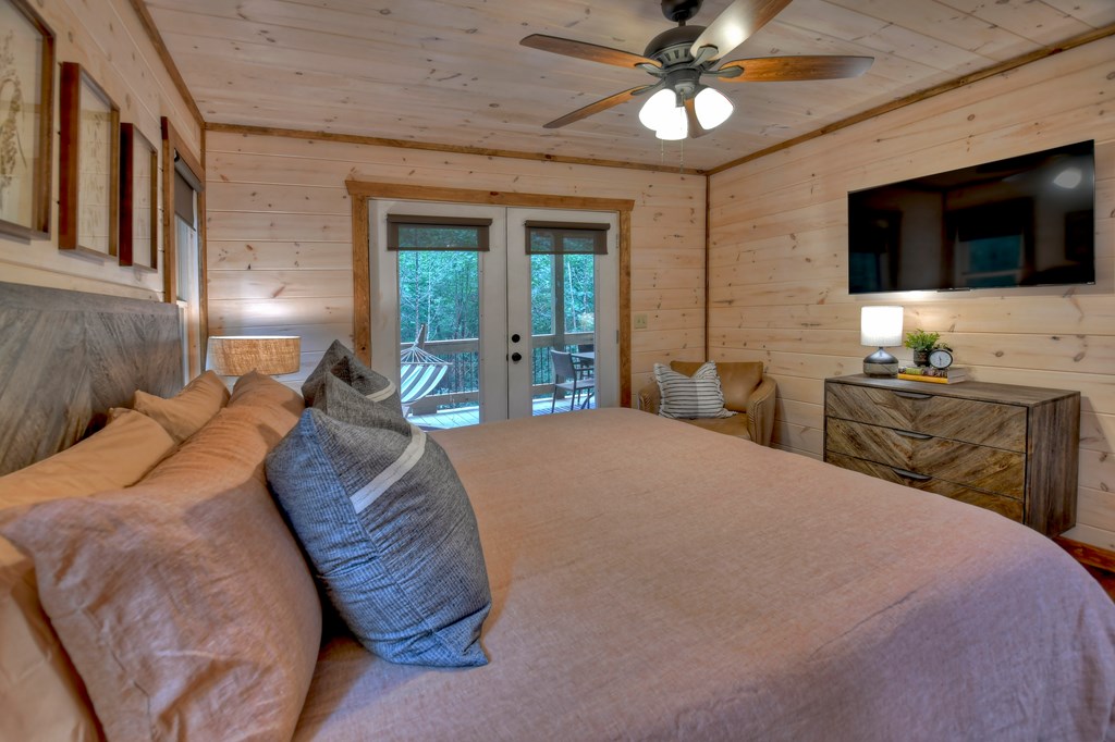 135 Windy Valley Lane Blue Ridge, GA 30513 - Photo 24 of 63 a spacious bedroom with a bed and a flat screen tv