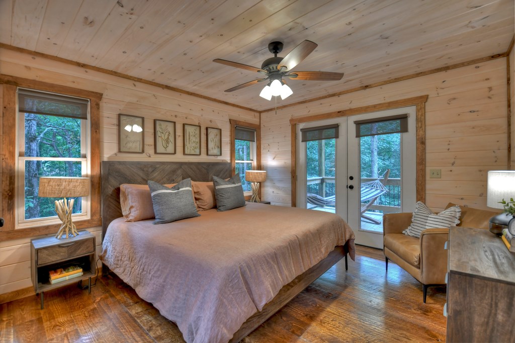 135 Windy Valley Lane Blue Ridge, GA 30513 - Photo 25 of 63 a bedroom with a large bed and a chandelier