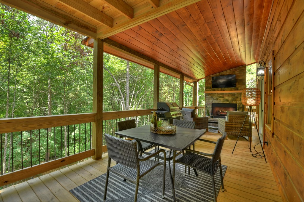 135 Windy Valley Lane Blue Ridge, GA 30513 - Photo 30 of 63 a view of a patio with table and chairs and wooden floor
