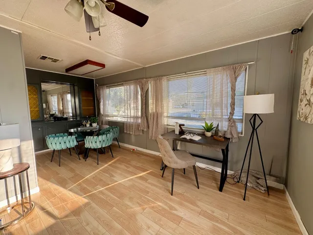 a living room with patio furniture and a wooden floor
