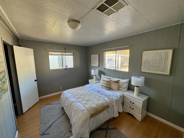 a bedroom with a bed and wooden floor