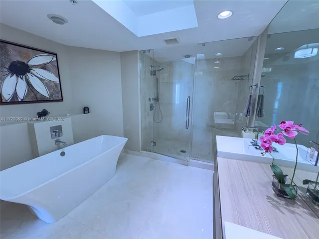 a bathroom with a sink vanity tub and shower