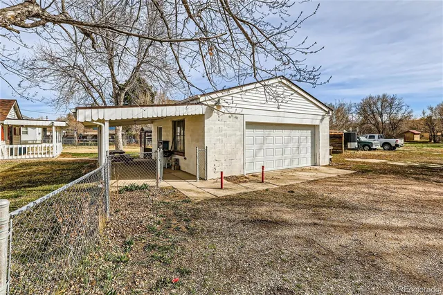 a backyard of a house with large trees and outdoor seating