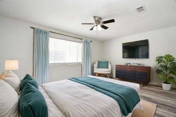a bedroom with a bed window and a flat screen tv
