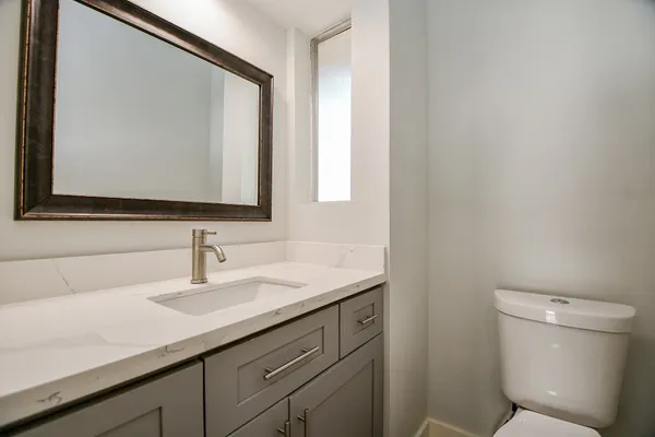 a bathroom with a toilet sink and mirror