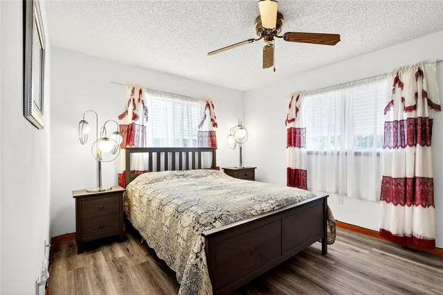 a bedroom with a bed a dresser and a chandelier