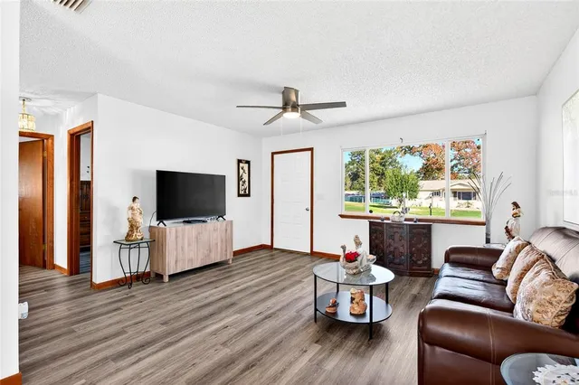 a living room with furniture a flat screen tv and a large window