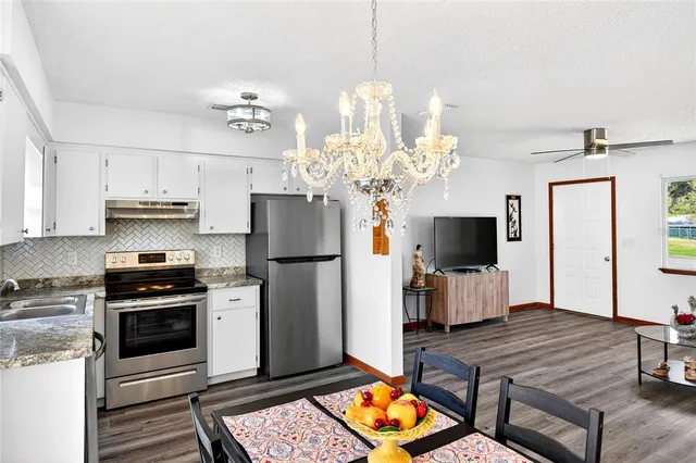 a kitchen with stainless steel appliances a stove refrigerator and microwave