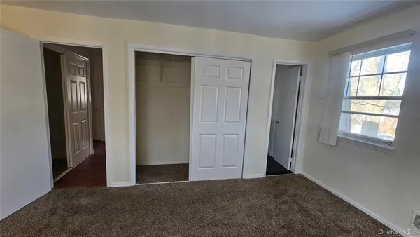 an empty room with windows and closet