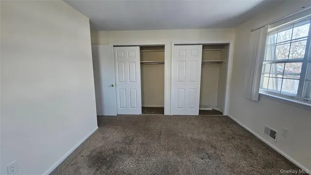 an empty room with windows and closet