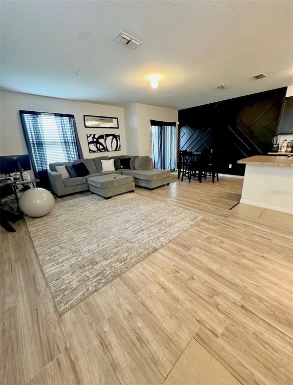 3640 Seneca Club Loop, Unit 46103 Orlando, FL 32808 - Photo 2 of 7 a living room with furniture and a flat screen tv