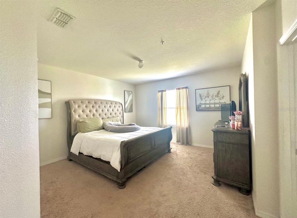 3640 Seneca Club Loop, Unit 46103 Orlando, FL 32808 - Photo 6 of 7 a spacious bedroom with a bed and window
