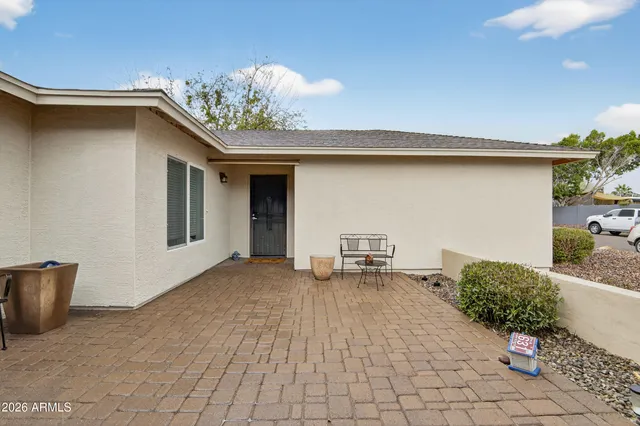 a view of a chair and table in the back yard of the house