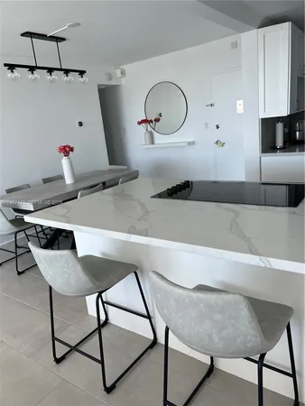 a kitchen with a table chairs and white cabinets