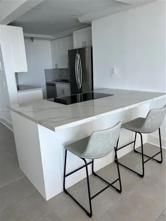 a kitchen with kitchen island cabinets and sink