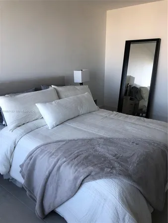 a bedroom with a bed and a mirror